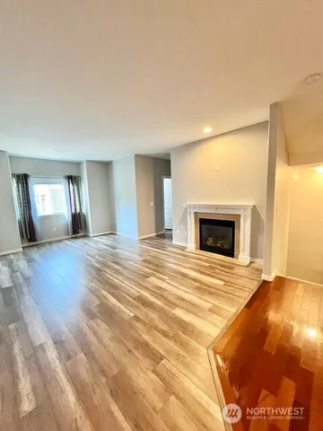 a view of empty room with wooden floor and fireplace