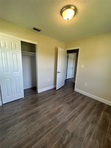 an empty room with wooden floor and closet