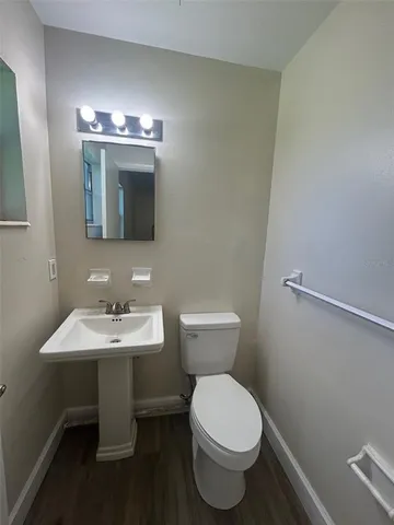 a bathroom with a toilet a sink and mirror
