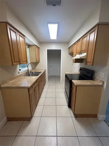 a kitchen with a sink a counter space and cabinets