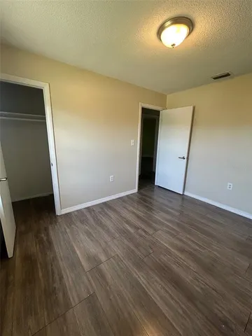 an empty room with wooden floor and closet