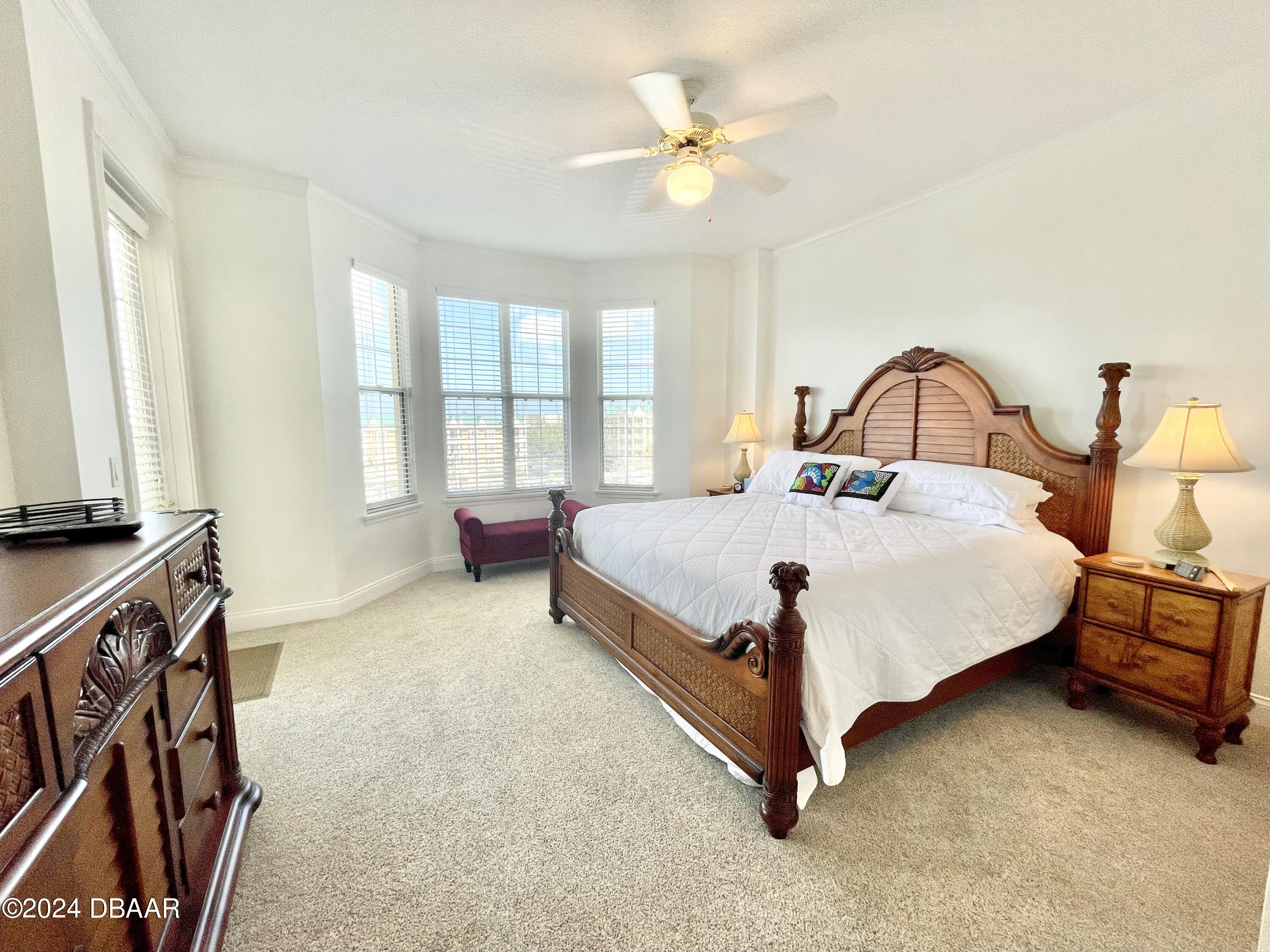 4626 Harbour Village Boulevard, Unit 3505 Ponce Inlet, FL 32127 - Photo 14 of 38 a large bed sitting in a room next to a window with a chandelier