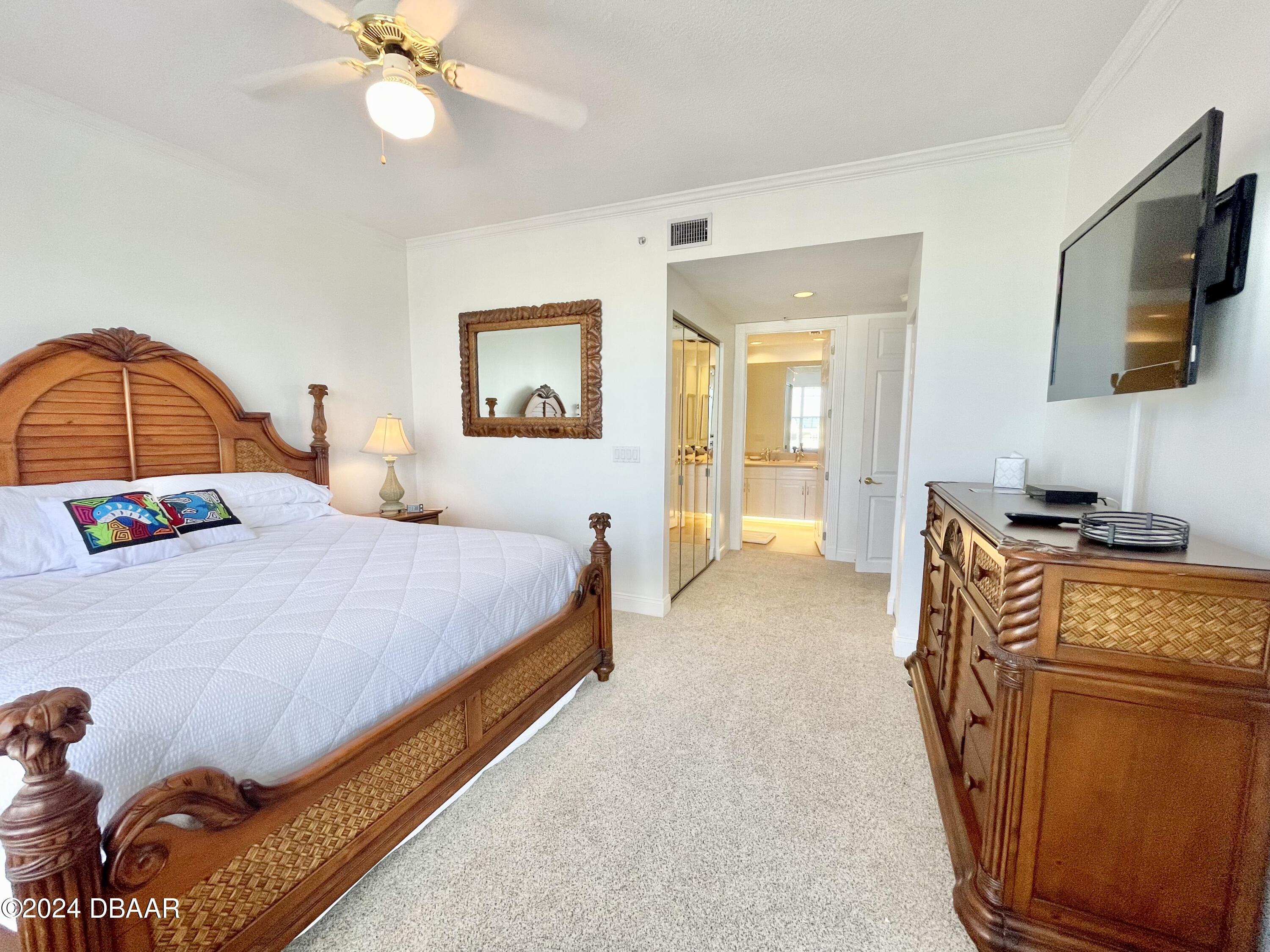 4626 Harbour Village Boulevard, Unit 3505 Ponce Inlet, FL 32127 - Photo 17 of 38 a spacious bedroom with a bed and a flat screen tv