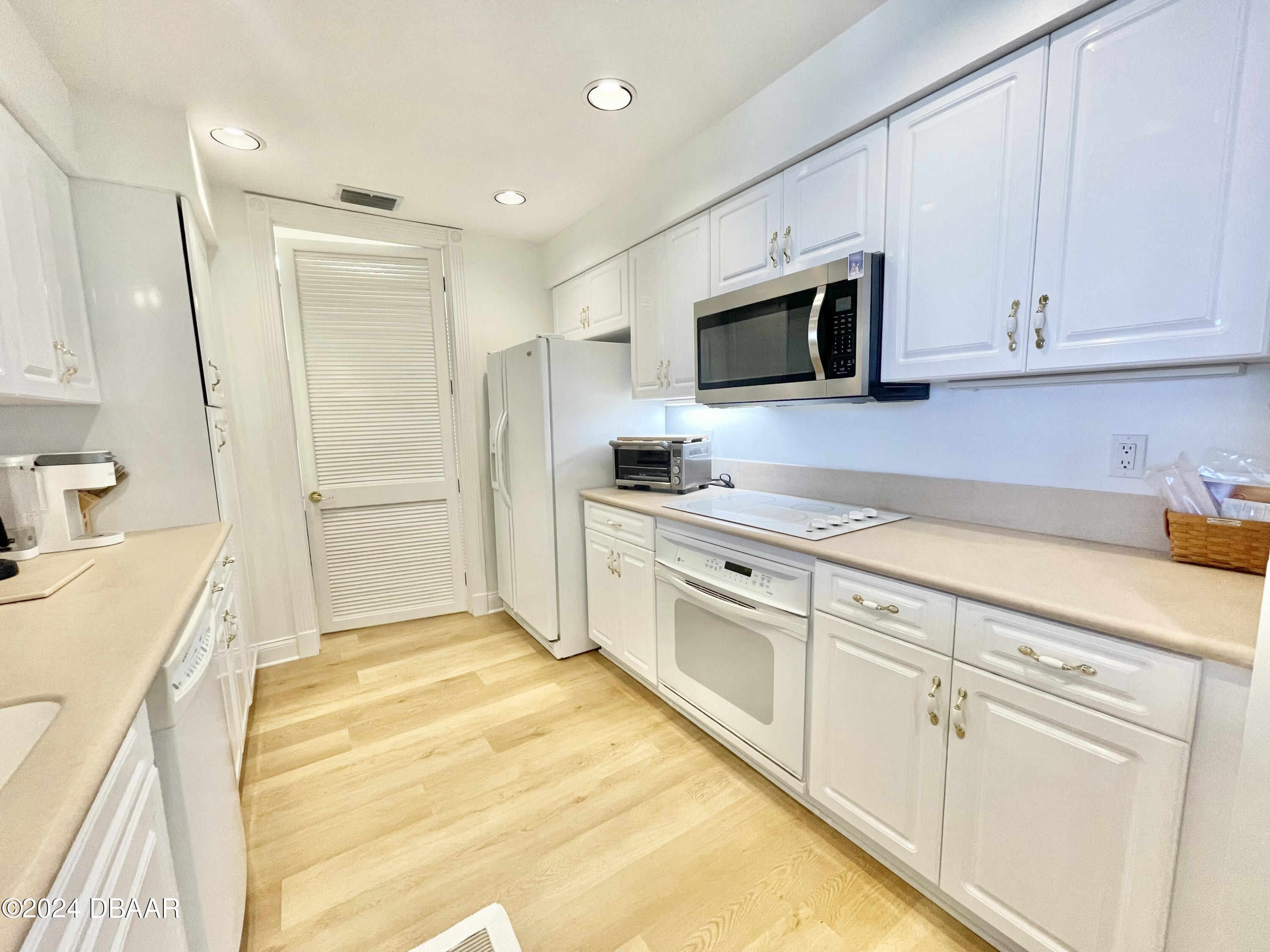 4626 Harbour Village Boulevard, Unit 3505 Ponce Inlet, FL 32127 - Photo 6 of 38 a kitchen with granite countertop white cabinets and stainless steel appliances