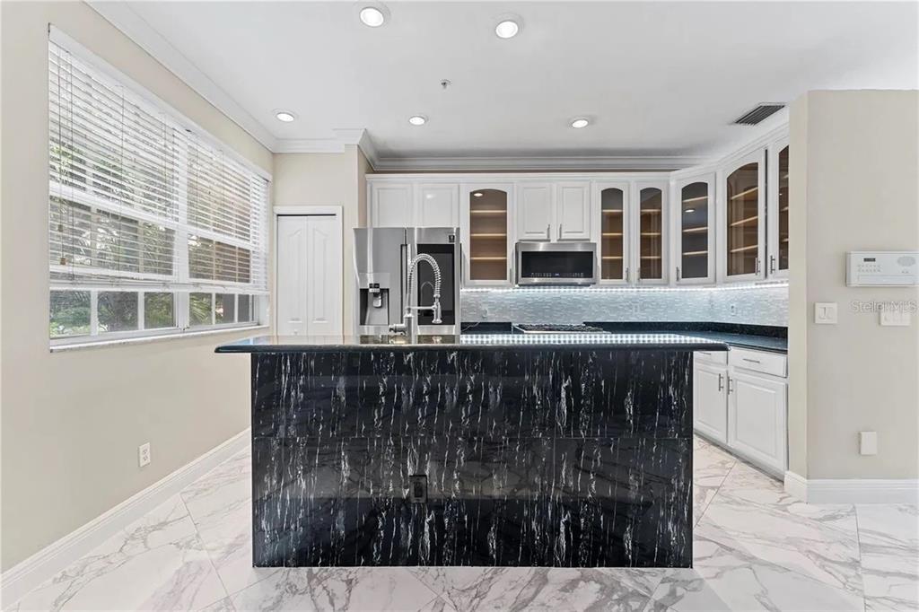 1437 Harbour Walk Road Tampa, FL 33602 - Photo 8 of 32 a kitchen with kitchen island granite countertop a sink and wooden cabinets