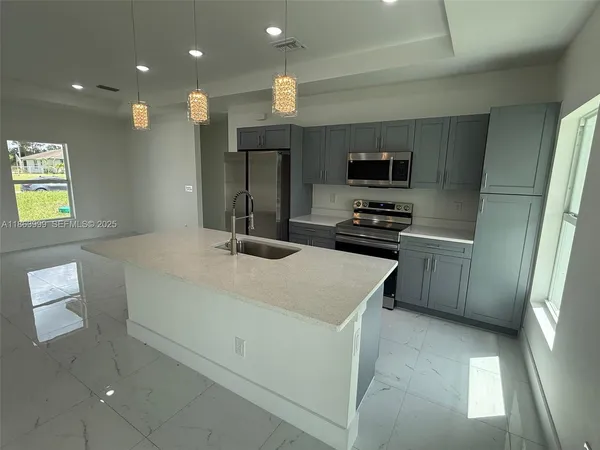 a kitchen with a sink stainless steel appliances and cabinets