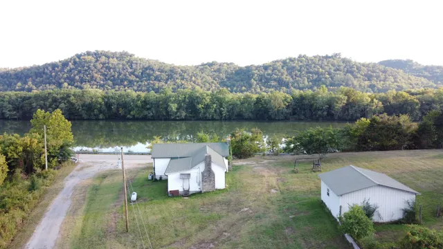 an aerial view of a house with garden space and a lake view