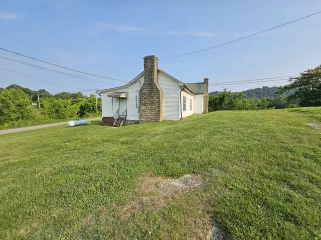 an aerial view of residential houses with outdoor space and trees