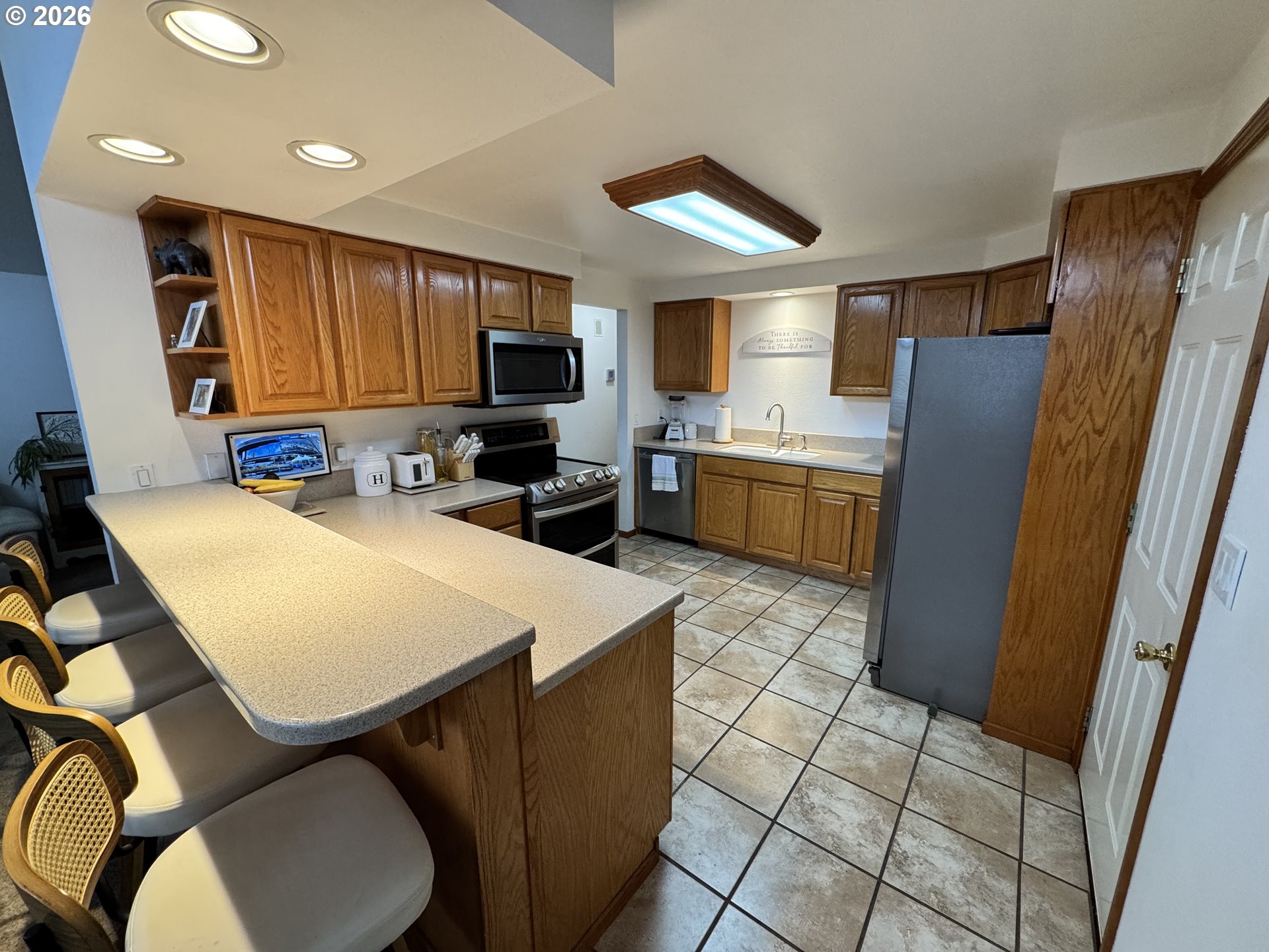 1091 Longridge Drive Springfield, OR 97478 - Photo 5 of 21 a kitchen with stainless steel appliances granite countertop a refrigerator a sink a stove top oven a dining table and chairs