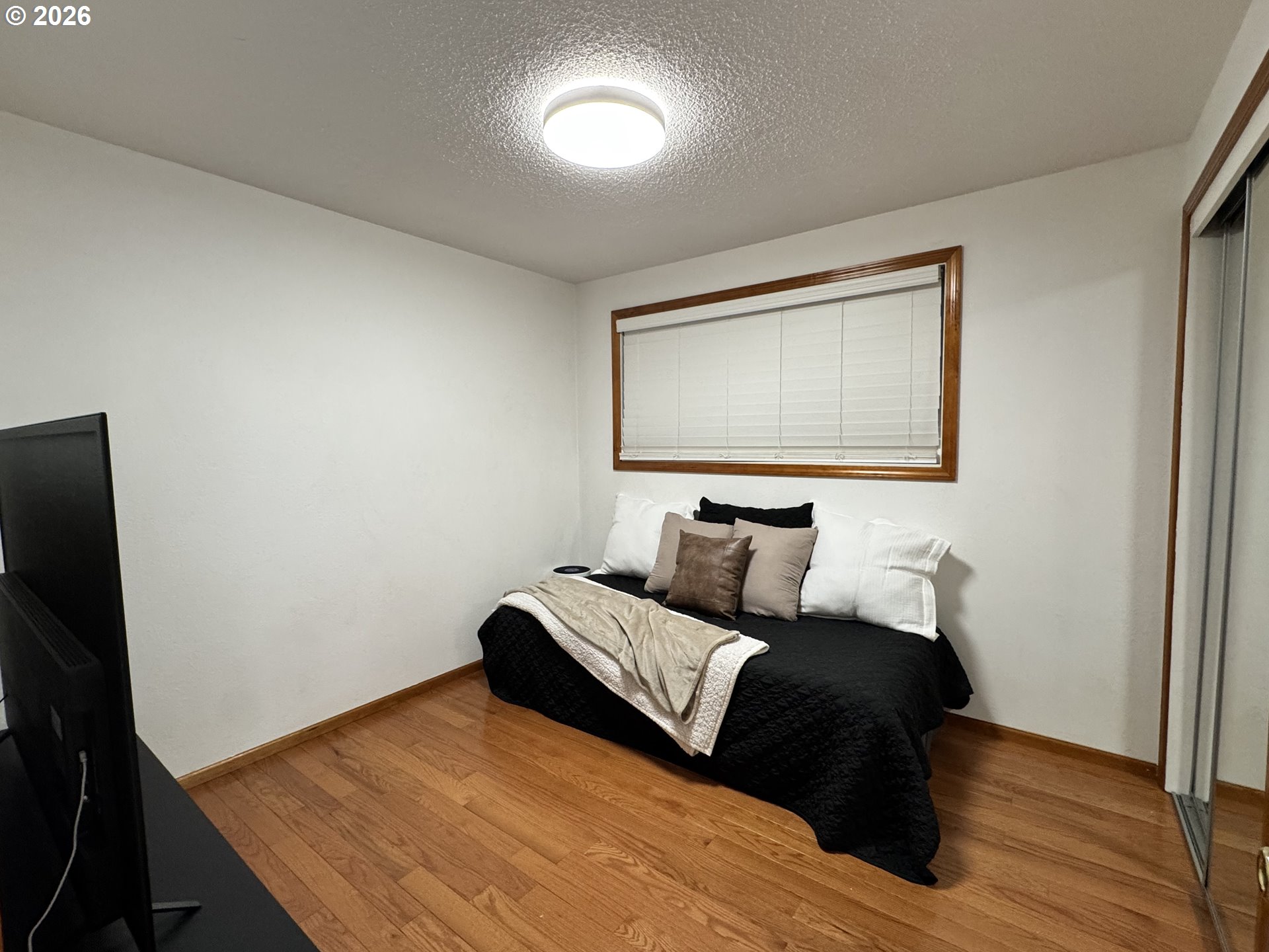 1091 Longridge Drive Springfield, OR 97478 - Photo 9 of 21 a bedroom with a bed and a flat tv screen on a dresser