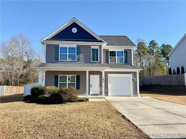 a front view of a house with a yard and garage