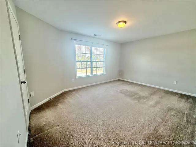 an empty room with windows and mirror