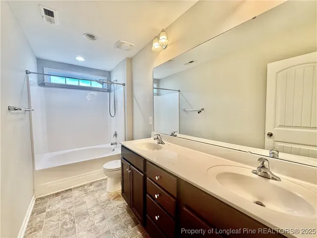 a bathroom with a sink double vanity granite tub shower and a mirror