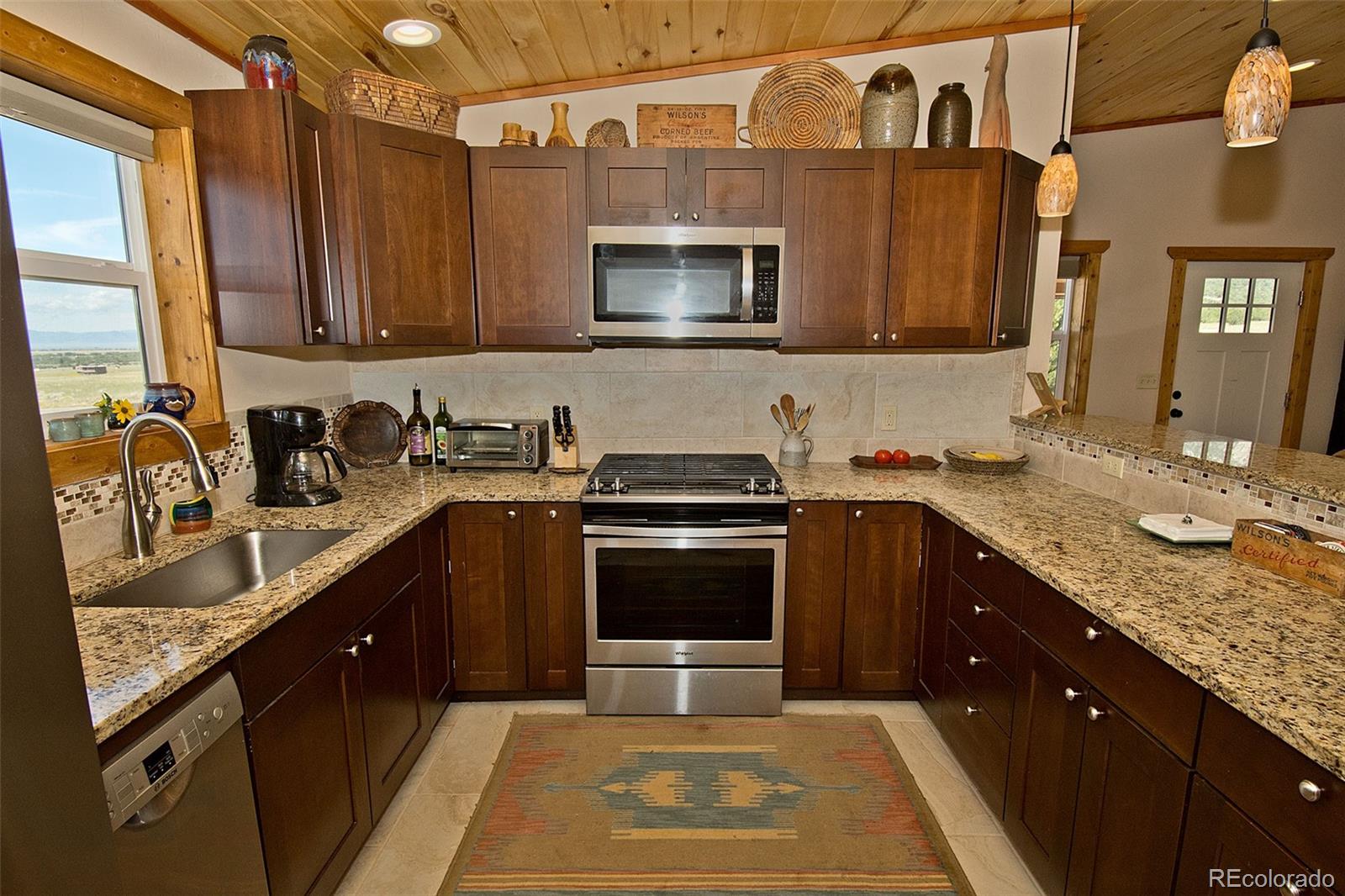 3421 Camino Del Rey Crestone, CO 81131 - Photo 15 of 41 a kitchen with stainless steel appliances granite countertop a sink stove and microwave