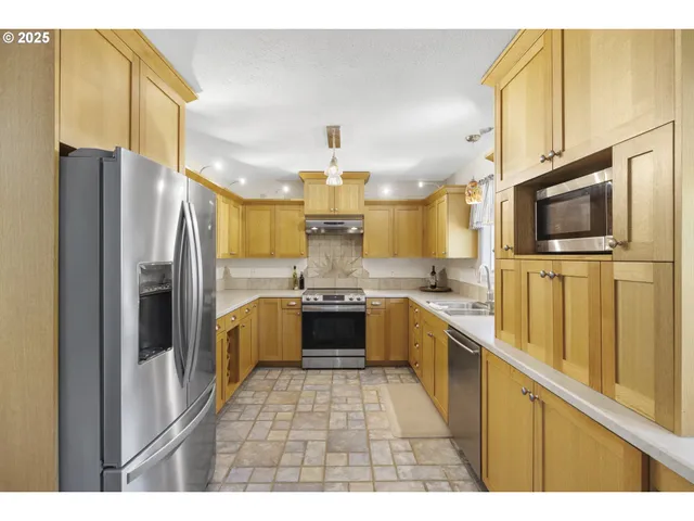 a kitchen with stainless steel appliances a refrigerator sink and microwave