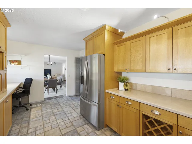 a kitchen with a sink a refrigerator and wooden cabinets