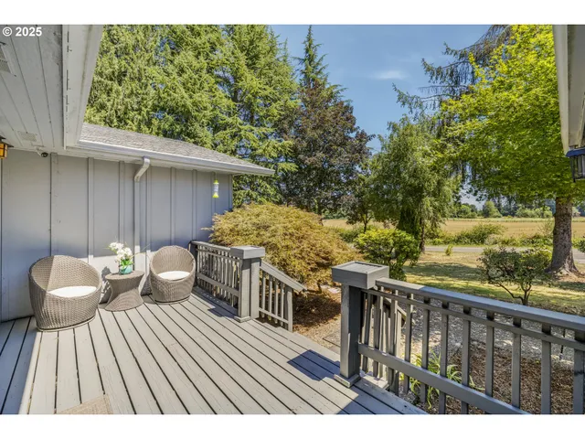 a balcony with wooden floor and outdoor seating