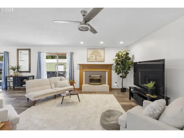 a living room with furniture a large window and a fireplace