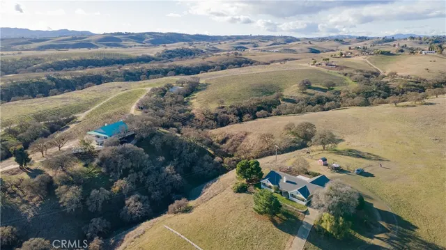 a view of a house with a big yard and large trees