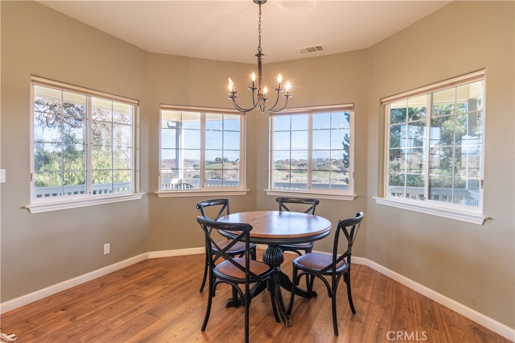 390 San Marcos Road Paso Robles, CA 93446 - Photo 38 of 62 a dining room with wooden floor a chandelier a wooden table and chairs