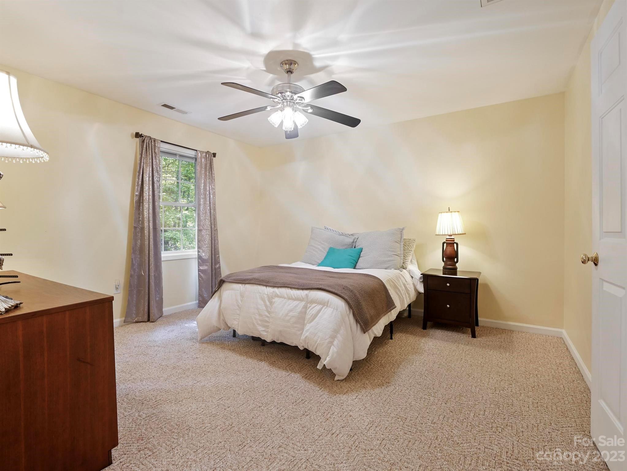 25 Falcon Crest Drive Fairview, NC 28730 - Photo 17 of 41 a spacious bedroom with a bed and a chandelier