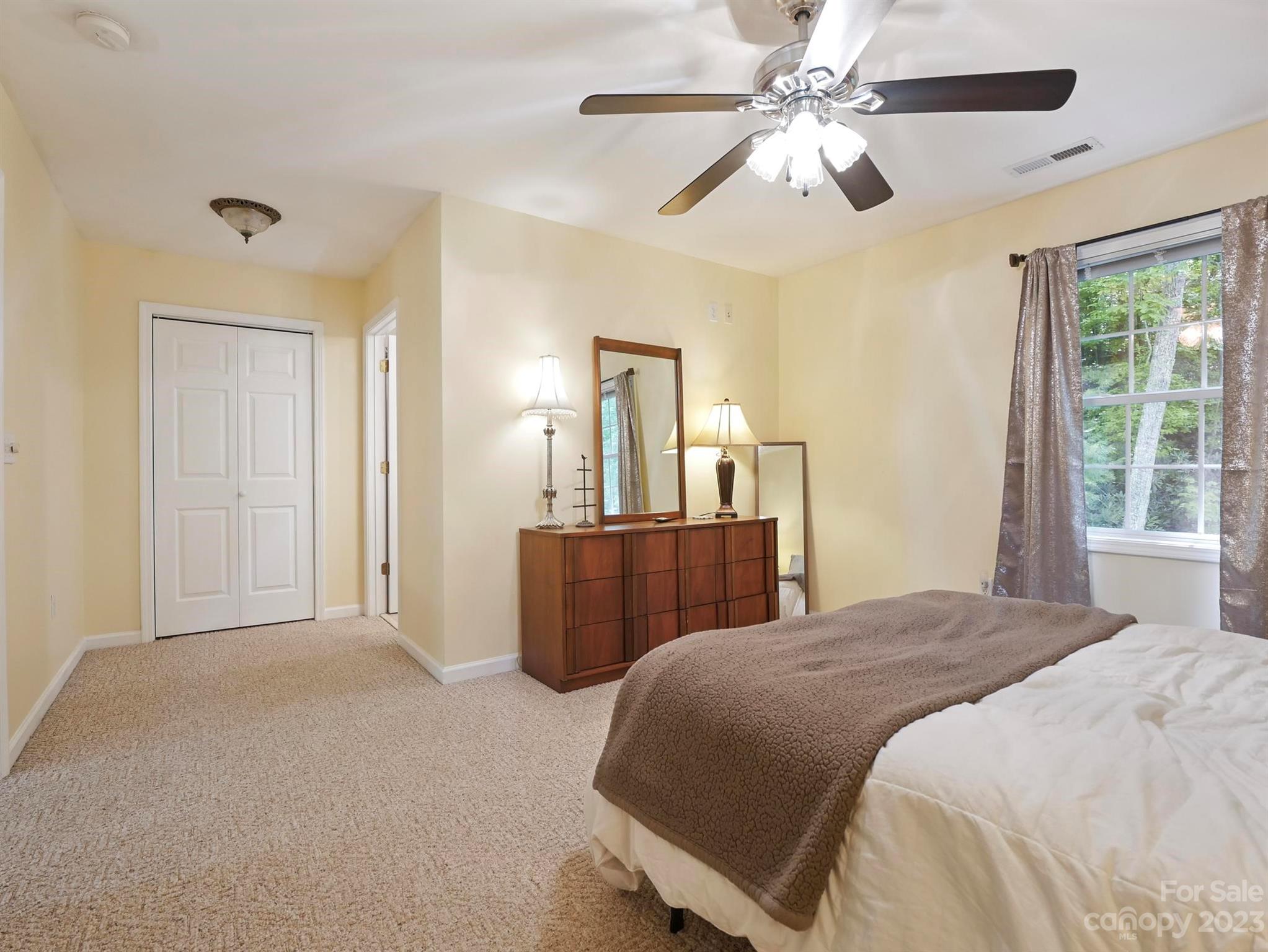 25 Falcon Crest Drive Fairview, NC 28730 - Photo 18 of 41 a bedroom with a large bed a chandelier and a window