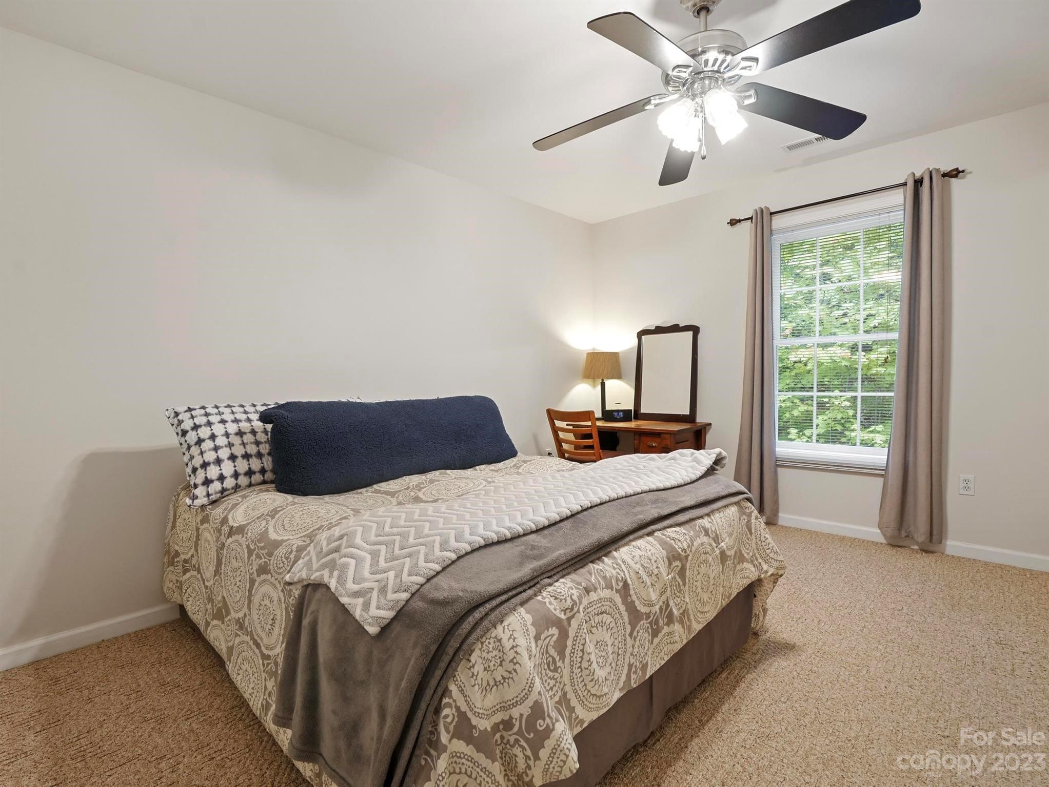 25 Falcon Crest Drive Fairview, NC 28730 - Photo 20 of 41 a bedroom with a large bed and a chandelier