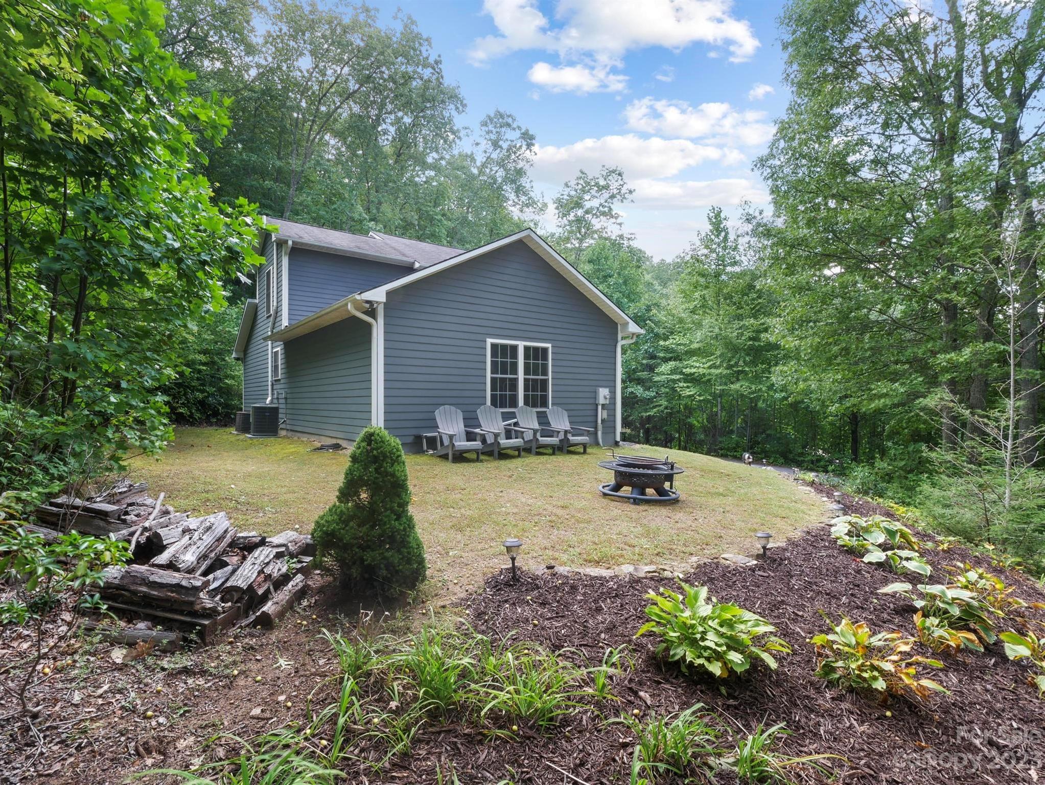 25 Falcon Crest Drive Fairview, NC 28730 - Photo 32 of 41 a view of a house with backyard outdoor seating area and trees around