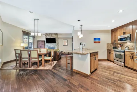 a living room with stainless steel appliances kitchen island furniture and a wooden floor