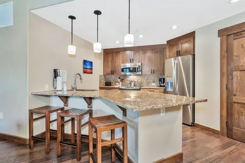 a kitchen with stainless steel appliances granite countertop a sink stove and microwave