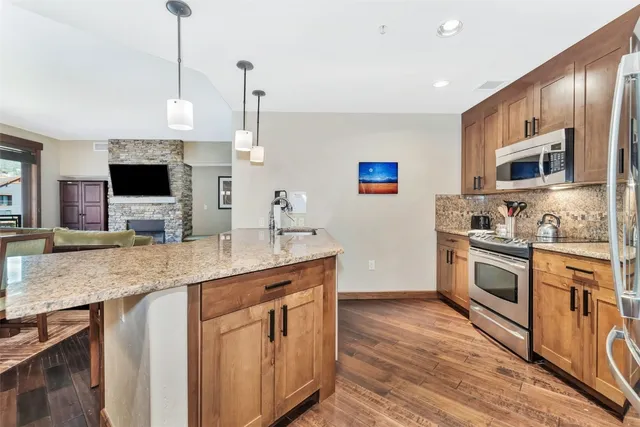 a kitchen with stainless steel appliances granite countertop a sink and a stove top oven