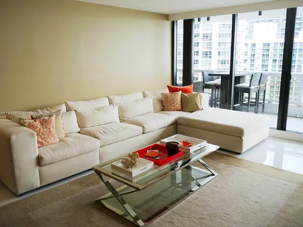 a living room with furniture and a floor to ceiling window