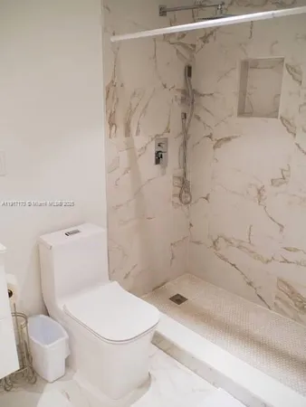 a bathroom with a toilet and a shower