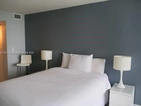 a bedroom with a bed and a lamp