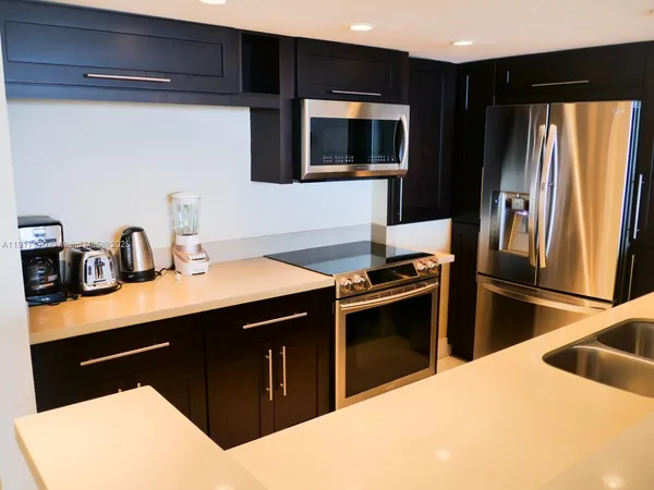 a kitchen with stainless steel appliances kitchen island a sink stove and refrigerator