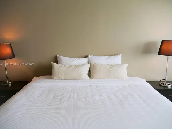 a large bed sitting in a bedroom and lamp