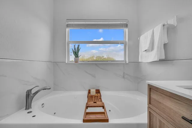 a bathroom with a bathtub and window