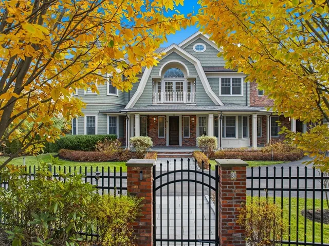 a front view of a house with a garden and trees