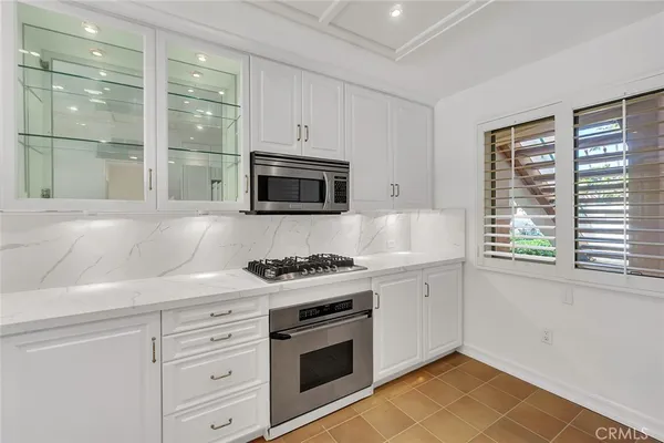 a kitchen with granite countertop a stove a sink and a microwave