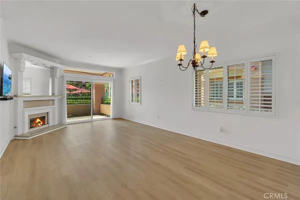 a view of a room with wooden floor and chandelier
