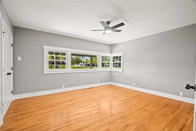 a view of empty room with wooden floor