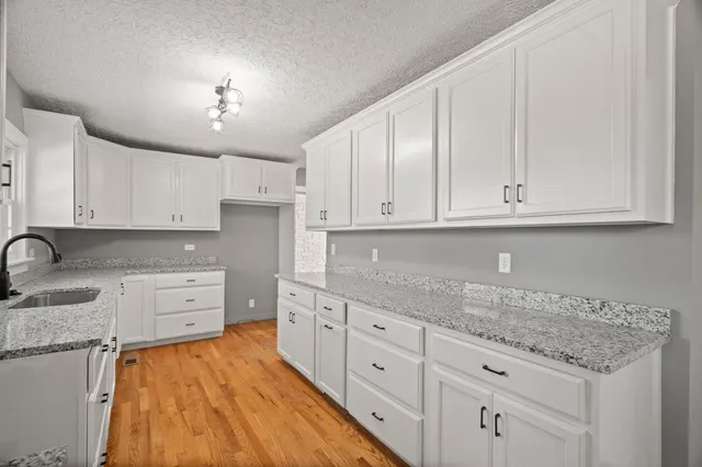 an empty room with windows and fireplace