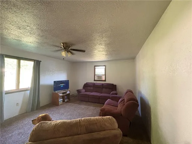 a living room with furniture a ceiling fan and a window