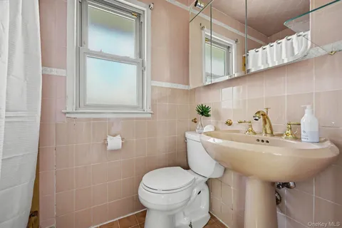 a bathroom with a sink toilet and a mirror