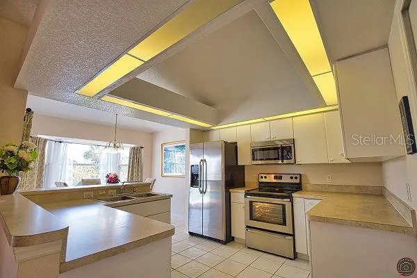 a kitchen with stainless steel appliances a refrigerator and a stove top oven