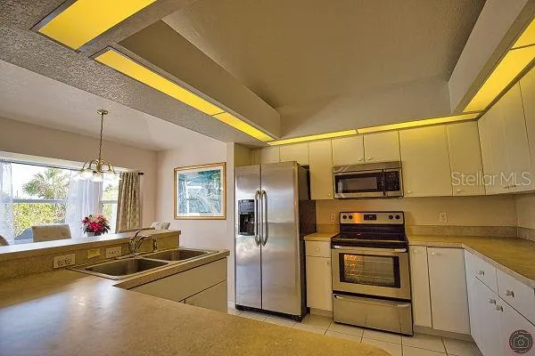 a kitchen with stainless steel appliances a stove a sink a microwave and refrigerator