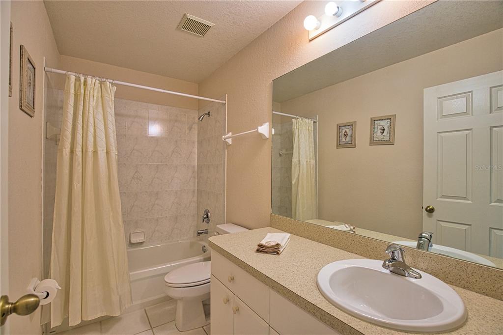 116 Albatross Road Rotonda West, FL 33947 - Photo 16 of 28 a bathroom with a double vanity sink toilet mirror and shower