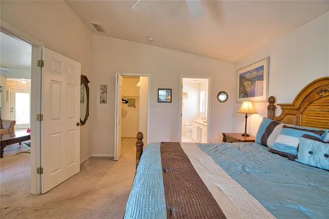 a bedroom with a large bed and a chandelier