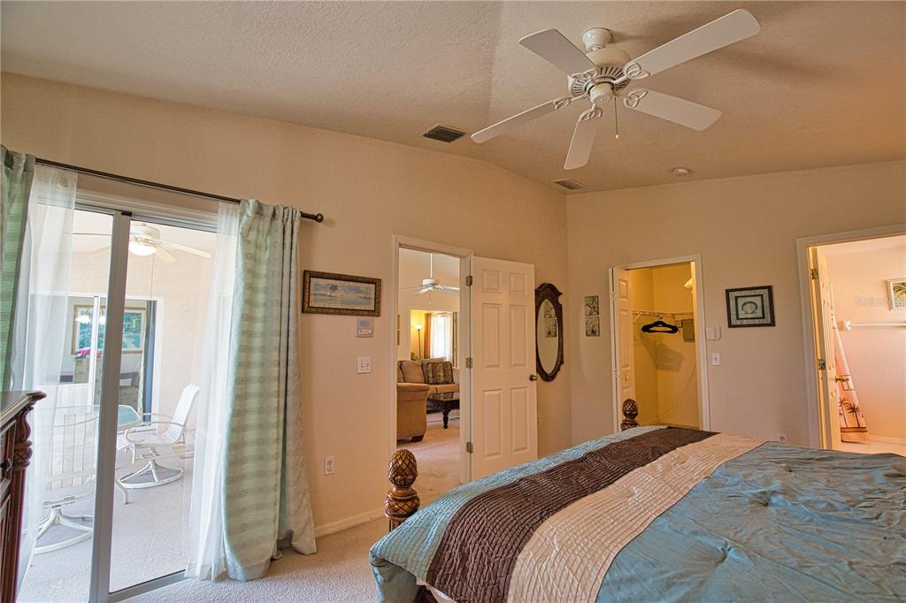 116 Albatross Road Rotonda West, FL 33947 - Photo 21 of 28 a bedroom with a large bed and a chandelier