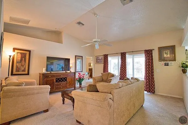 a living room with furniture flat screen tv and window
